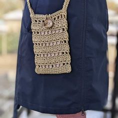 a woman is holding a crocheted purse