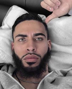 a man with a beard laying in bed