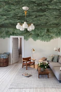 the living room is decorated with green trees