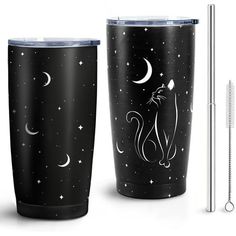 two black tumblers with white cats on them and one has a straw in it