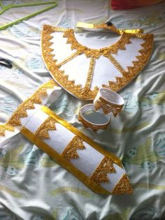 a table topped with white and gold items on top of a bed covered in sheets