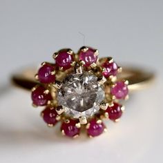 Like the heroine of The Great Gatsby, this hand-crafted diamond ring is quite the character. Hand-cut champagne diamond - 0.80 carats - encircled by ruby petals. A brilliant engagement ring, treasured gift, or a beautiful addition to your collection. Hand-crafted of 14k gold. Available in sizes 5-8. Daisy Engagement Ring, Brilliant Engagement Rings, Diamond And Ruby Ring, Daisy Buchanan, Treasure Gift, Replica Jewelry, Gold Champagne, Spring Jewelry, Stud Jewelry