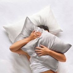 a woman laying in bed with her head on the pillow