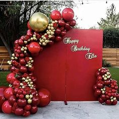 a large red and gold balloon arch with balloons