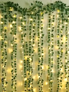 a bed sitting under a window covered in green ivy vines and lights on the wall