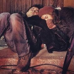 a man and woman laying on the ground next to each other with their eyes closed