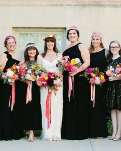 a group of women standing next to each other in dresses and holding bouquets on their heads