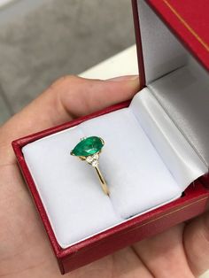 This ring features a 1.06-carat natural Colombian emerald, pear cut from the famous Muzo mines. Set in a secure two-prong setting, this extraordinary emerald has a stunning green color and very good eye clarity, Minor imperfections are normal for genuine Colombian emeralds. Three brilliant round diamonds accent the emerald on either side. Excellent colorless diamonds with VS clarity highlight the pear cut emerald. Set in silky 18K yellow gold. Perfect for everyday wear. Metal Purity: 18K Yellow Pear-shaped Solitaire Emerald Ring For Gift, 14k Yellow Gold Pear-shaped Emerald Ring, Pear-shaped Gold Emerald Ring In 14k Gold, Columbian Emeralds, Colorless Diamond, Colombian Emeralds, Emerald Engagement, Silver Engagement Rings, Emerald Engagement Ring