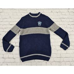 a blue and white sweater hanging on a brick wall