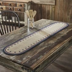 an old wooden table with some utensils on it and a place mat in the middle