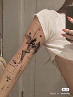 a woman with a tattoo on her arm taking a selfie in front of a mirror