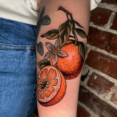 an orange with leaves and flowers on the arm