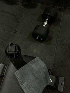 an overhead view of a gym equipment with towel and dumbbells on the floor