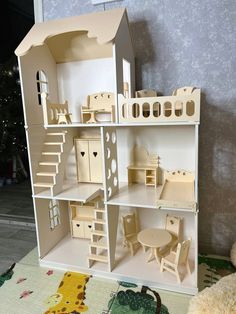 a doll house with all the furniture and accessories on display in front of a teddy bear