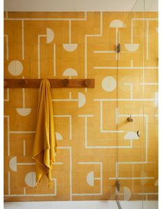 a yellow towel hanging on the wall next to a shower