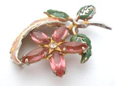 Floral Jewelry - This is a gold plated pot metal flower and leave brooch / pin with pink and clear rhinestones and pink and green enamel. The brooch measures 2.5" by 2". Pink Flower Enamel Brooch, Vintage Pink Enamel Brooch Pin, Vintage Pink Enamel Pin Brooch, Vintage Pink Enamel Brooches, Pink Flower Brooch Pins, Vintage Pink Brooch Pin, Pink Flower Enamel Pin, Vintage Pink Enamel Pin Gift, Pink Costume Jewelry Brooch For Gift