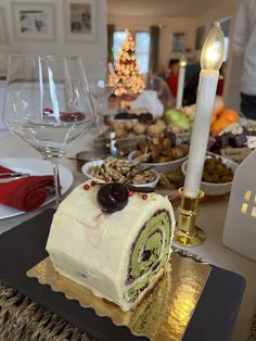 there is a cake that has been cut in half and served on the table with wine glasses