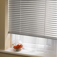 a vase with flowers in it sitting on a window sill next to the blinds