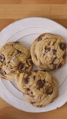 four chocolate chip cookies on a white plate