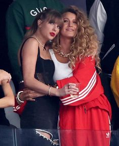 two women hugging each other in the stands