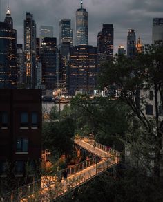 the city skyline is lit up at night with lights on and people walking across it