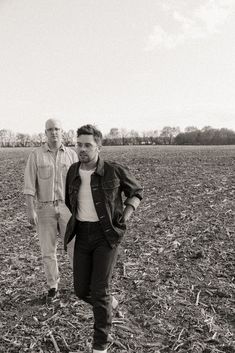 two men standing in the middle of a field