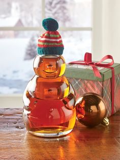 a glass vase filled with liquid next to a christmas ornament on a table