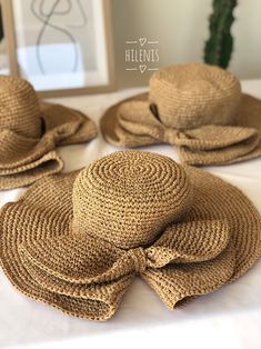 three straw hats are sitting on top of a white table with a mirror in the background