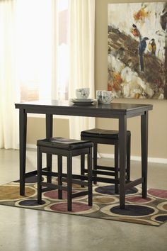 a dining room table with two stools and a vase on top of the table