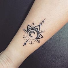 a tattoo on the arm of a woman with an arrow and sun in the middle