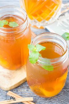 two jars filled with liquid sitting on top of a wooden table