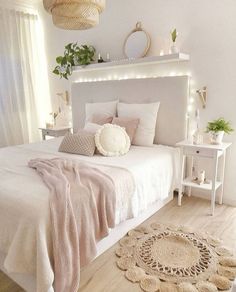 a bedroom with white walls and wooden flooring is decorated in neutral tones, such as pink