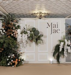 the floral arrangements are on display in front of the white walls and ceilinging at the entrance to the venue