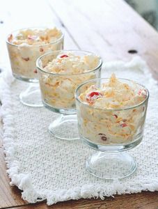 three glasses filled with food sitting on top of a white cloth next to a wooden table