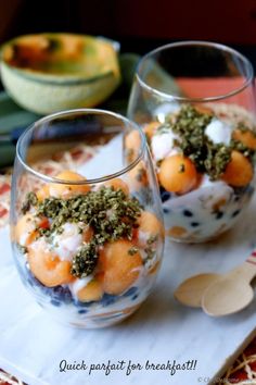 two glasses filled with food sitting on top of a table