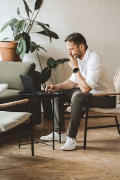 a man sitting in a chair on his laptop