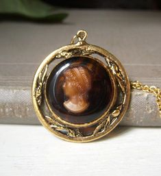 Vintage brown glass lady cameo pendant necklace. This unsigned necklace is circa-1960's.  Goldtone metal with brown glass background.  Cameo is glass, I think. Chain measures 16" and closes with a spring-lock clasp. Wonderful Victorian look to this.  In great shape! Sorry, but no international shipping at this time. Please see my shop for more vintage, estate jewelry: nightowlmemories.etsy.com Vintage Cameo Jewelry For Formal Occasions, Antique Brown Necklace For Collectors, Vintage Intaglio Pendant Jewelry, Victorian Brown Necklace For Gift, Vintage Brown Necklace For Gifts, Vintage Brown Necklace For Gift, Victorian Brown Collectible Jewelry, Vintage Brown Jewelry Gift, Victorian Style Brown Collectible Jewelry