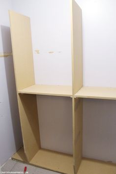 an empty shelf in the corner of a room with white walls and no one around it