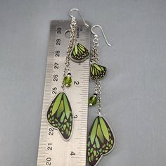 Butterfly Wing Earrings Green Monarch Butterfly Wings Earrings Long Dangle Drop Earrings Magical Fairy Wing Earrings Colorful Wing Earrings I ship super fast.  These super fun lightweight earrings are so pretty. The beads are wire wrapped and connected to the chain.  The wings are connected to the chain.  They are all gathered on a jumpring and connected to the ear wires. The wings are made of resin.  They are double-sided.  The beads are glass crystals.  The chain is non-tranish silver plated and the ear wires are Sterling Silver.  They ship with rubber backs to prevent loss in a delightful organza bag perfect for gift giving. Whimsical Hypoallergenic Dangle Earrings, Whimsical Butterfly Ear Wire Jewelry, Whimsical Butterfly Jewelry With Ear Wire, Whimsical Green Dangle Jewelry, Fairy Style Jewelry With Matching Earrings Gift, Whimsical Green Jewelry, Green Fairy Earrings For Gift, Handmade Fairy Dangle Jewelry, Green Dangle Chandelier Earrings