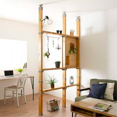 a living room filled with furniture next to a white table and wall mounted planters