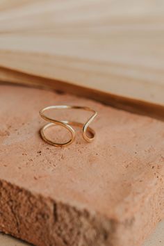 Our Revolve Cuff is such a crowd pleaser we made a ring version of it and the obsession is real. Wire is hand-shaped and hammered for texture. Available in 14kt Gold Fill + Sterling Silver. Wear it two ways: open side up or down. Kimmie pairs it with two of our Confetti Ring and Teeny Tiny Bands. Abbie stacks it with our Beaded Ring and Squiggle Ring. Handmade in Eau Claire, WI. Our jewelry is handmade so each piece will be unique and may vary slightly from what is pictured. Reputation Ring, Confetti Ring, Copper Uses, Everyday Wear Jewelry, The Obsession, Midi Rings, Crowd Pleaser, Ring Sizer, Beaded Rings