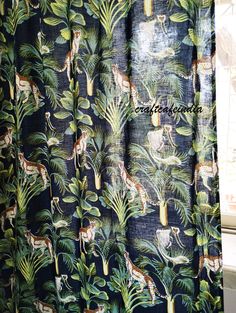 a curtain with giraffes and palm leaves on it