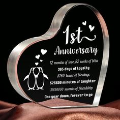 a glass heart shaped award with two penguins on it