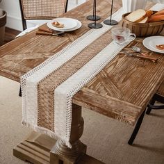 a wooden table topped with plates and glasses