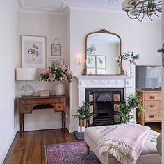 a living room filled with furniture and a fire place next to a mirror on the wall