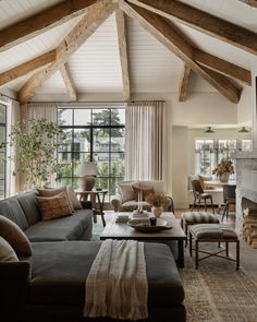 a living room filled with furniture and a fire place in front of a large window