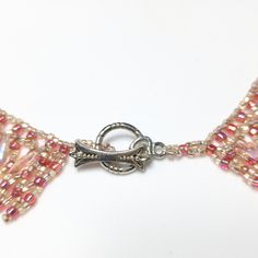 *Description: Beautiful hand made beaded collar necklace in shades of pink Czech glass beads; iridescent and darker pink. Teardrop shaped light pink iridescent beads are woven into the design as a drop bead. Silver tone decorative toggle clasp. Beautiful! This would be a great addition to your vintage jewelry collection or make a great vintage gift! *Approximate Measurements: Length - 17 Inches, Width - 1 Inch, Weight - 1.2 Ounces *Condition: Great vintage condition. May see signs of wear under Bohemian Pink Crystal Necklaces With Faceted Beads, Bohemian Pink Crystal Necklace With Faceted Beads, Pink Bohemian Crystal Necklace With Faceted Beads, Pink Beaded Crystal Necklaces With Round Beads, Pink Beaded Crystal Necklaces, Pink Beaded Necklaces With Lobster Clasp, Handmade Pink Crystal Necklaces With Round Beads, Pink Beaded Choker With Round Beads, Handmade Pink Choker With Round Beads