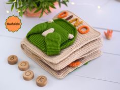 a stack of crocheted cloths sitting on top of each other next to a potted plant