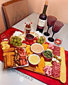 a table topped with wine glasses and lots of food