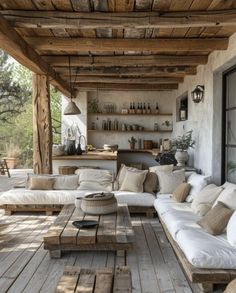 an outdoor living area with white couches and wooden tables